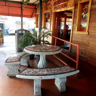 a table and benches in front of a restaurant