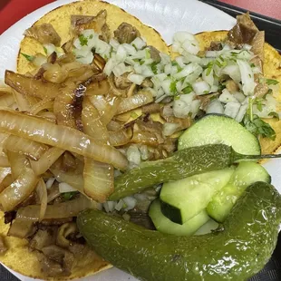 Buche tacos piled with onions and peppers