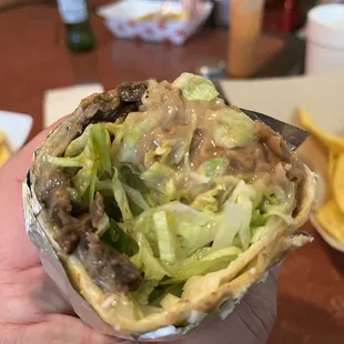 a hand holding a burrito