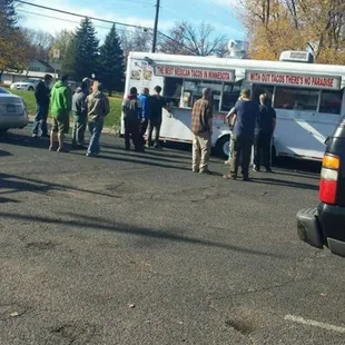 a group of people standing in a parking lot