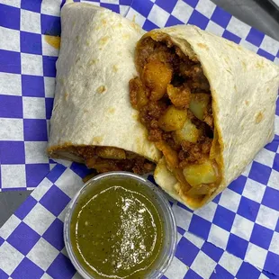 a burrito with a side of salsa