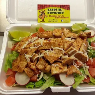 a salad in a styrofoam container