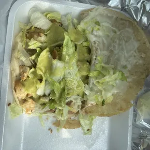 a chicken taco with lettuce and cheese