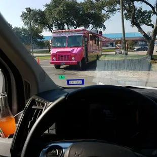 a pink truck driving down the road