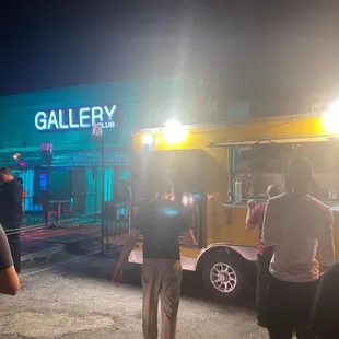 a group of people standing in front of a food truck