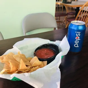 a bowl of chips and a can of pepsi