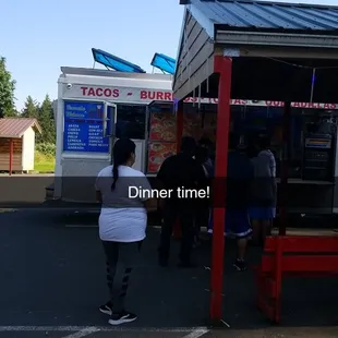 a woman standing in front of a food truck