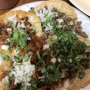 Al pastor tacos and asada tacos with cilantro and onions