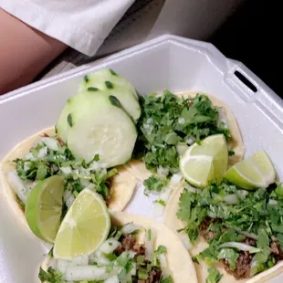 a person holding a tray of tacos