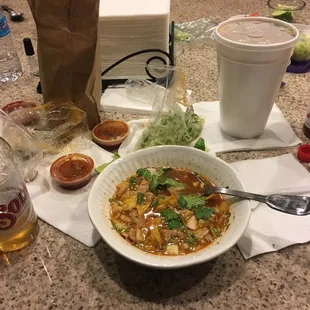 a bowl of soup and a bottle of beer