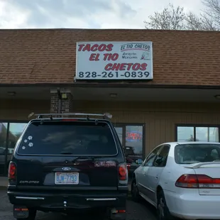two cars parked in front of a restaurant