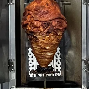 a large meat skewer being cooked