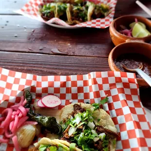 two plates of tacos and a bowl of salsa