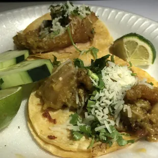 Chicharron tacos with a layer of refried beans at the bottom in chile verde sauce.