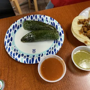 A couple of charred jalapeños and their salsa