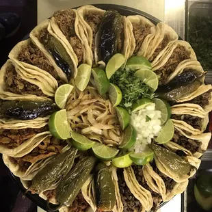 a plate of tacos and limes