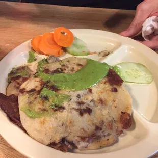 Bean and cheese pupusa with some dressings from the condiment bar.