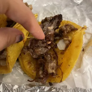 a hand reaching for a taco