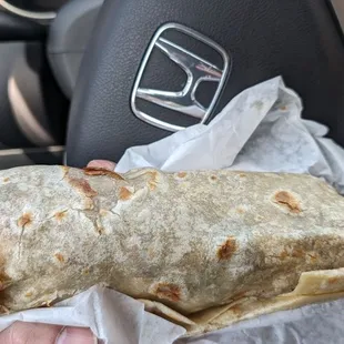 a hand holding a burrito