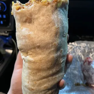 a hand holding a burrito