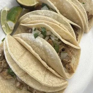 a plate of tacos and lime wedges