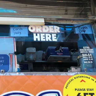 a taco stand with a sign that says order here