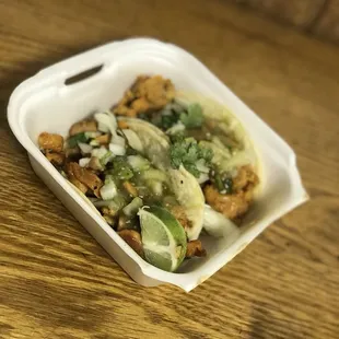 a takeout container of a taco dish