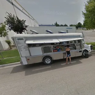 a woman standing in front of a food truck