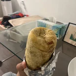 a person holding a burrito