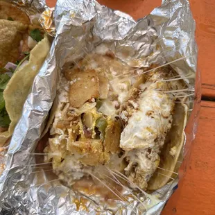 a close up of a taco wrapped in foil