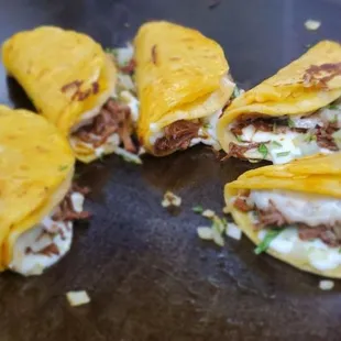 Quesabirria melty cheese shredded beef Birria with a sprinkle of fresh onions and cilantro.