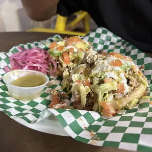 Sopes with grilled meat, cheese, lettuce, beans and sour cream with tomatoes