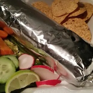 a burrito and vegetables in a styrofoam container