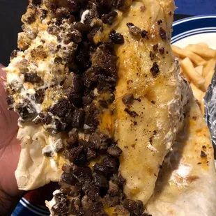 a hand holding a burrito