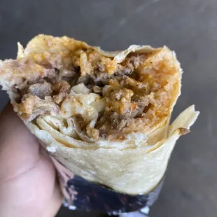  a hand holding a burrito