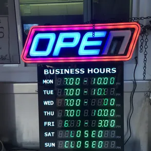 a neon open business hours sign