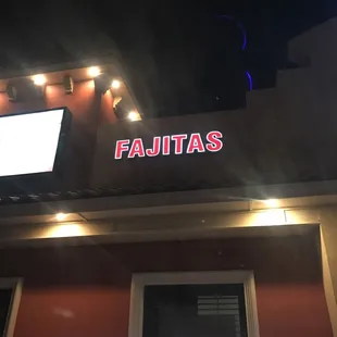 a neon sign on the outside of the restaurant