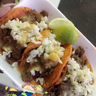 Tacos de asada with the tortilla dipped in a red sauce amazing even because they have cabbage.