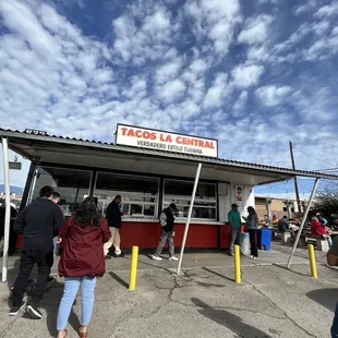 a group of people standing outside of a restaurant