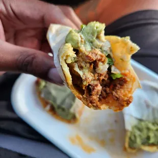 a hand holding a burrito