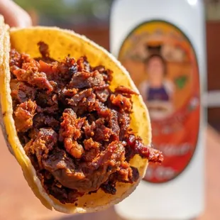 a hand holding a taco