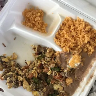 a white styrofoam container filled with rice, beans, and meat