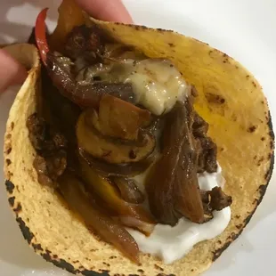 a hand holding a taco