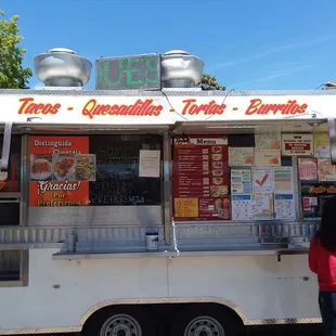a woman standing in front of a food truck