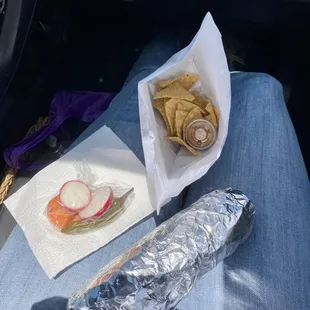 Super burrito with complimentary sides of chips, salsa, and pickled veggies