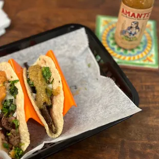 two tacoss on a tray