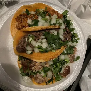 two tacoss on a paper plate