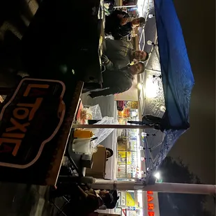 two people standing at a food stand