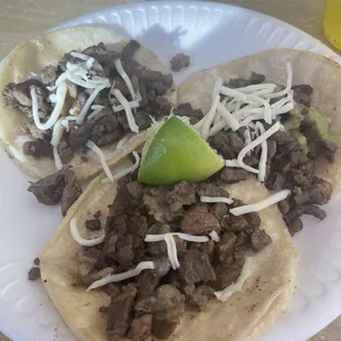 two tacoss on a paper plate