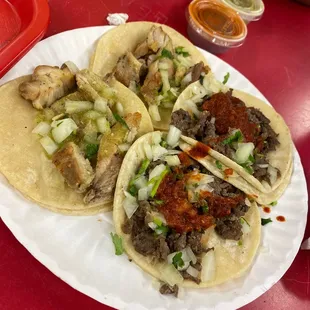 three tacoss on a paper plate